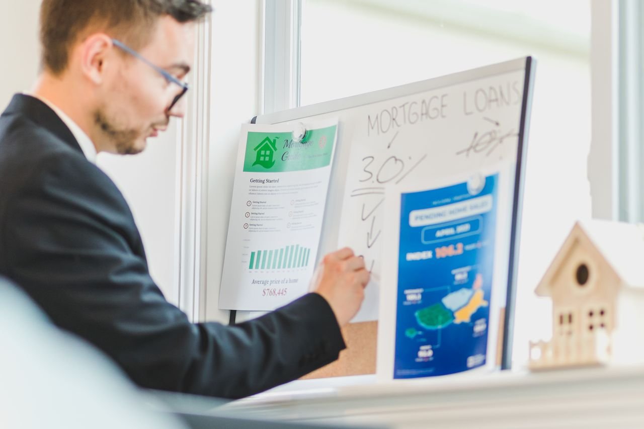 Home Real estate agent analyzing mortgage loan details on a whiteboard in an office setting.